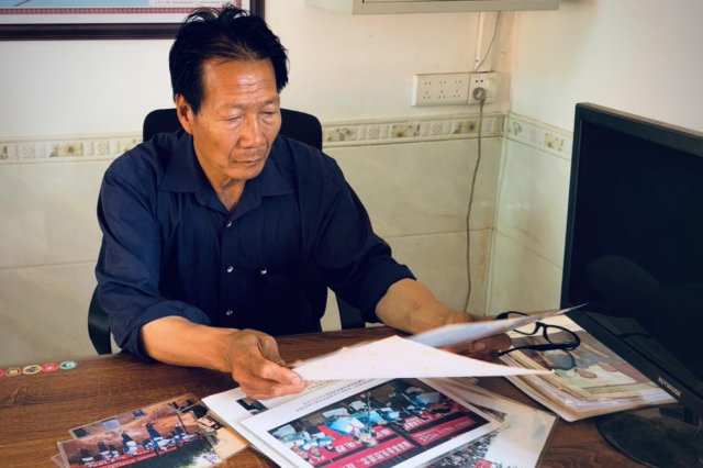 關連強隨身攜帶的一摞照片，記錄著十年來的點點滴滴。